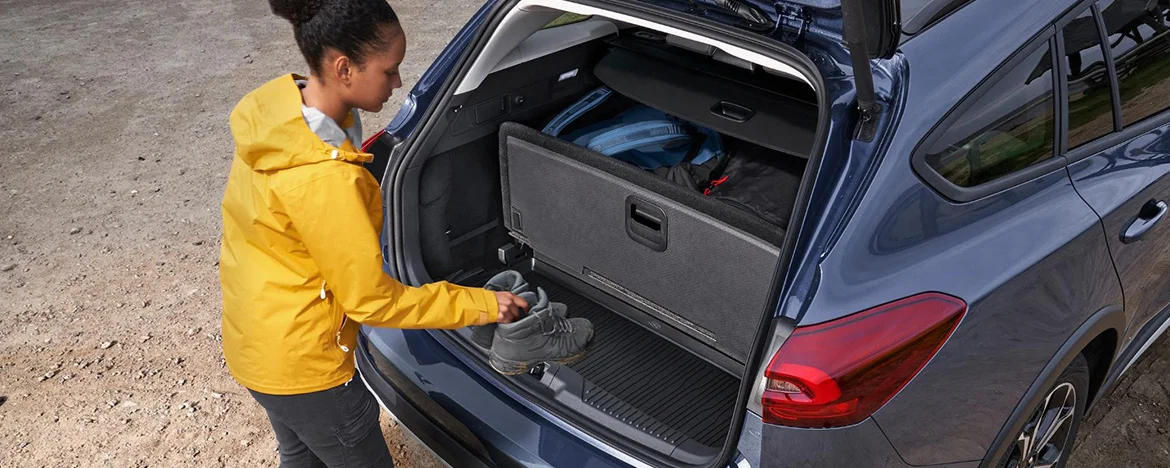 Lady putting boots into Ford Focus estate boot