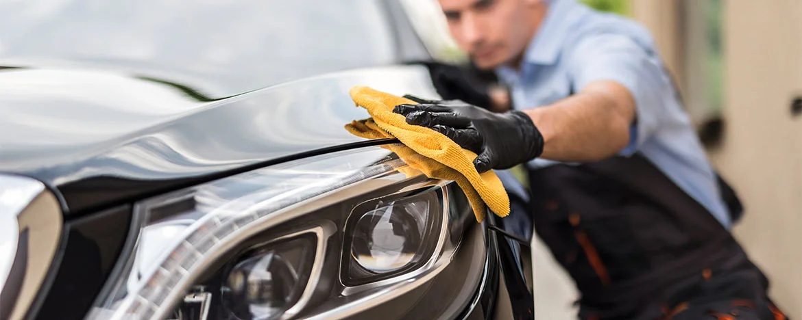 Man polishing a grey car bonnet