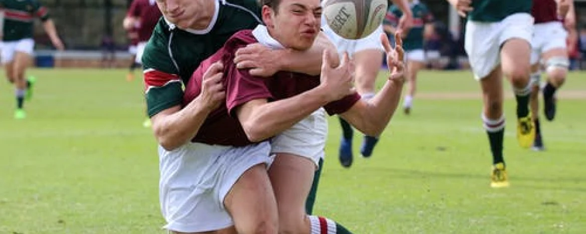 One rugby player tackling another