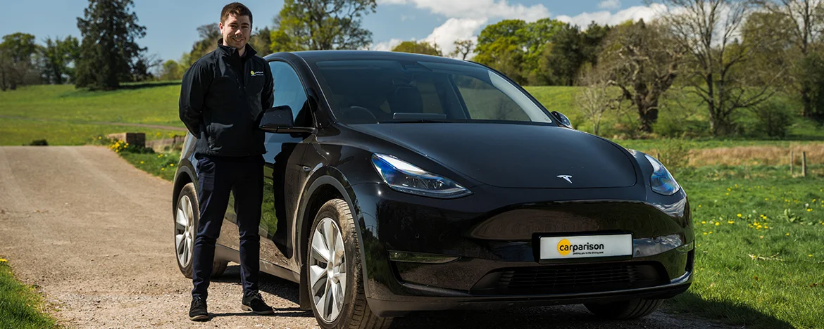 Carparison employee stood next to Tesla Model Y