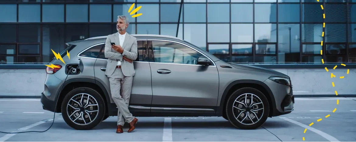 business man standing next to EV car on charge