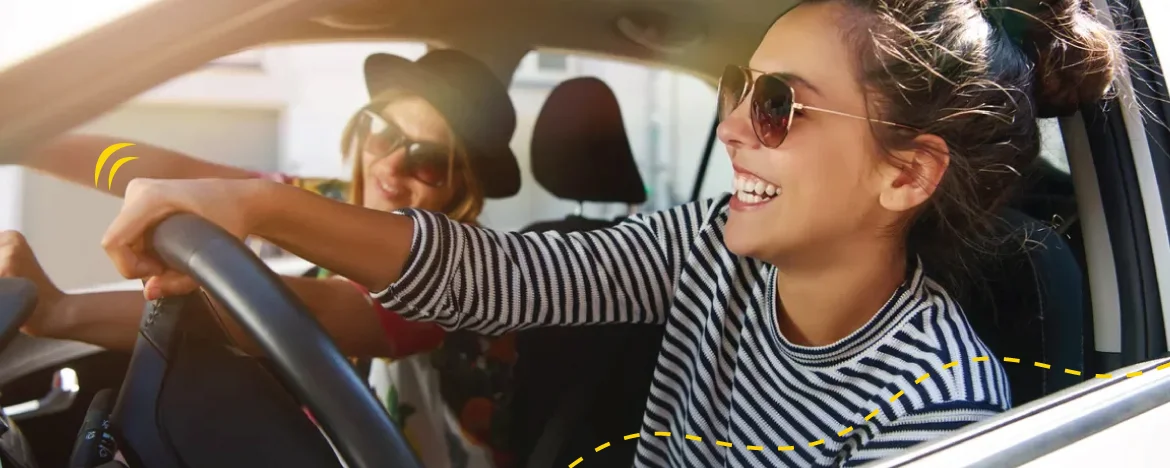 woman driving car smiling with sunglasses