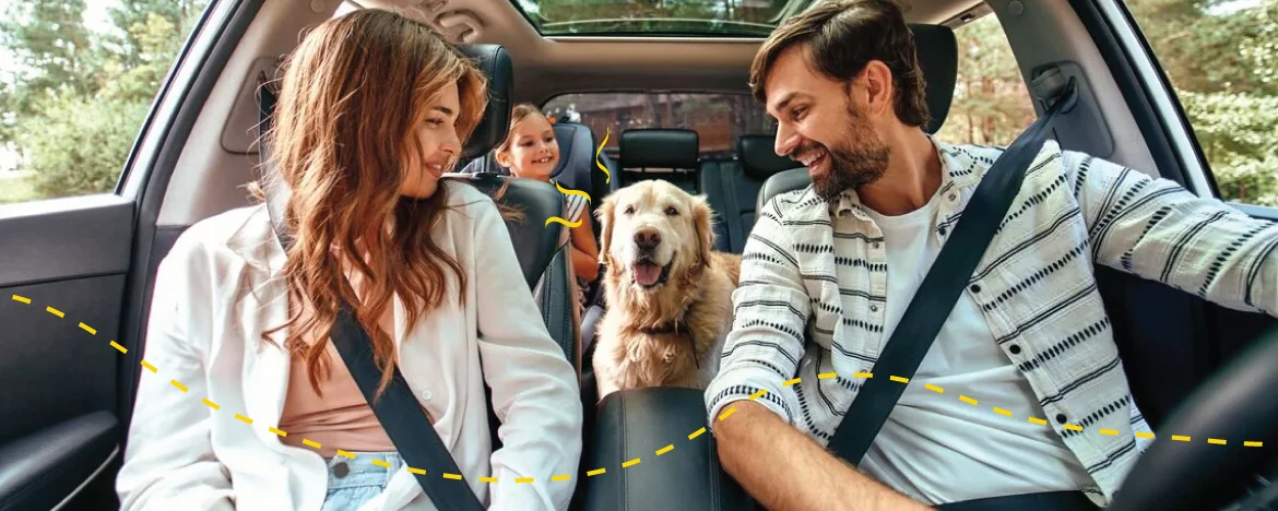 Happy family in car with dog