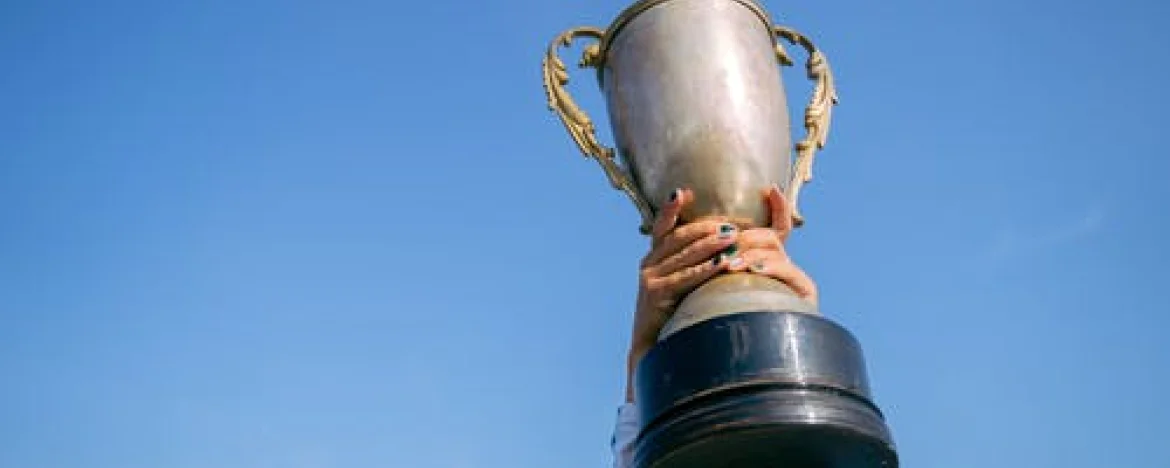 Person holding aloft a trophy