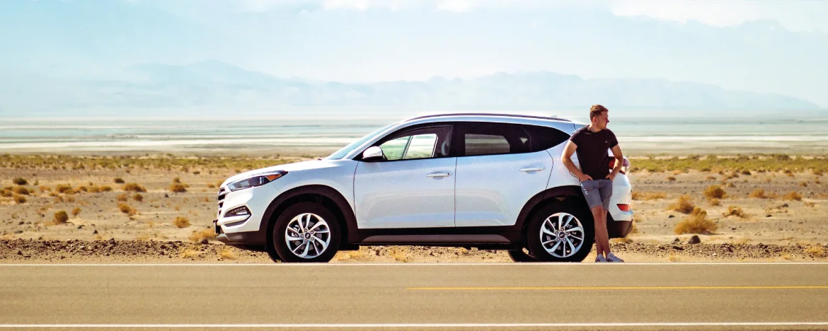 man standing next to car 