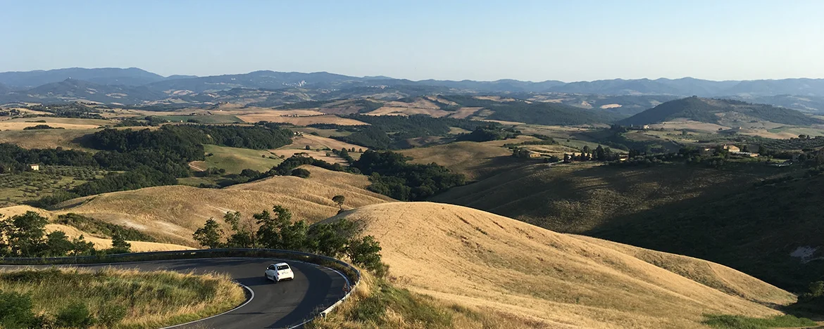 White Abarth 595 driving in Italian hills