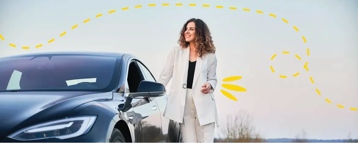 woman in suit standing next to car smiling