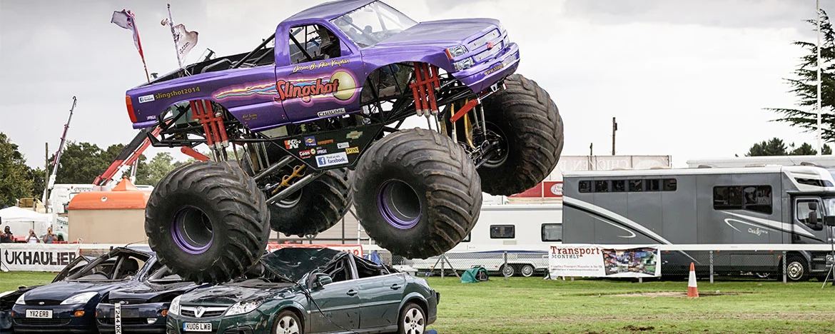 Monster truck jumping over flattened cars
