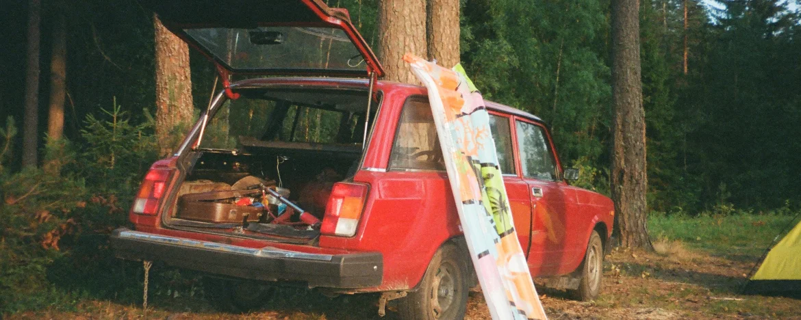 A small red car on a remote camping site