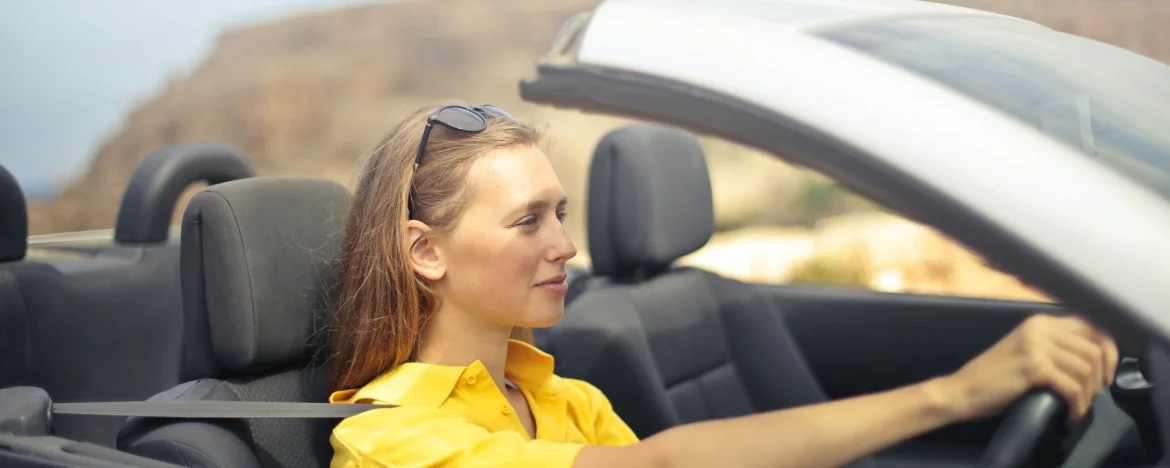 Woman driving a convertible car with the roof down