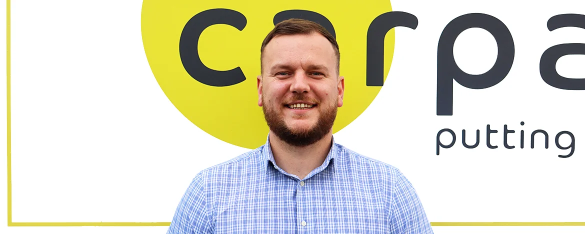 Ben stood in front of yellow carparison sign