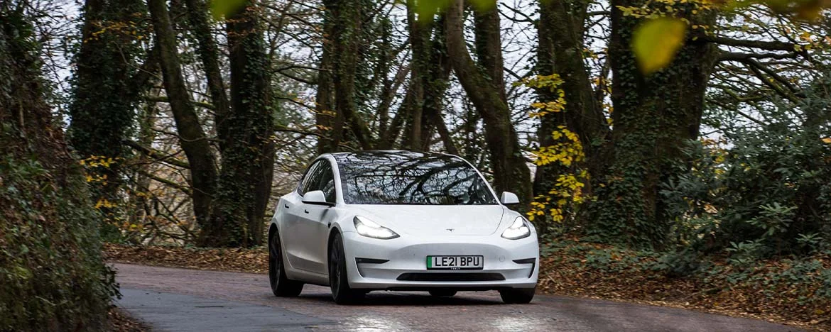 Tesla Model 3 driving around a corner