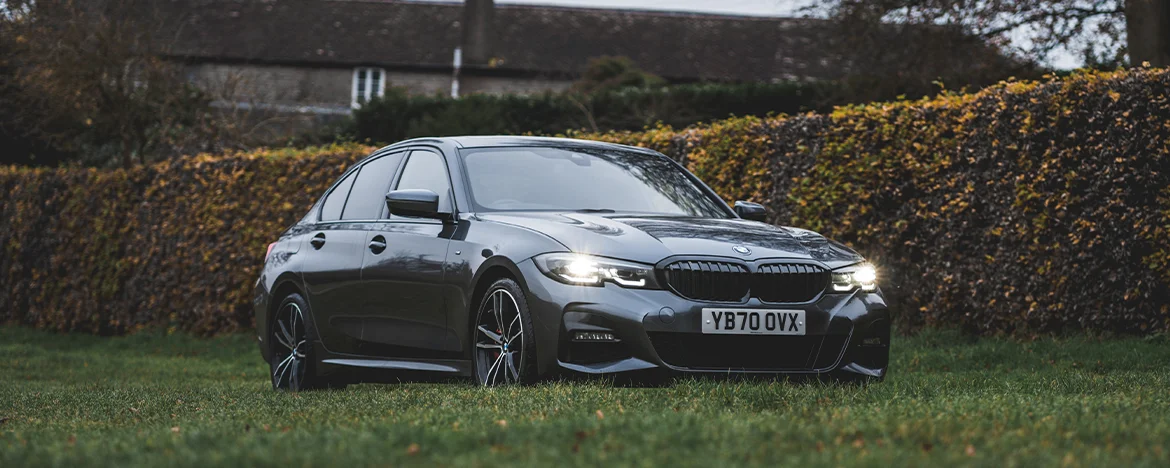 BMW 330e parked by bush