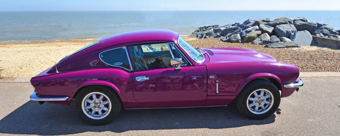 Triumph GT6 Mark III in Magenta parked up at the seafront