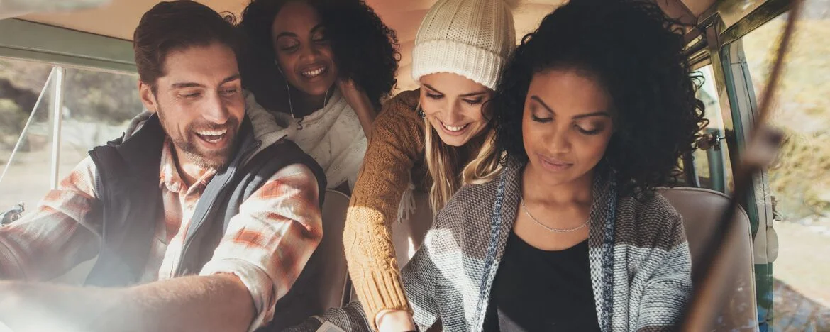 Group of friends in their car looking at road map