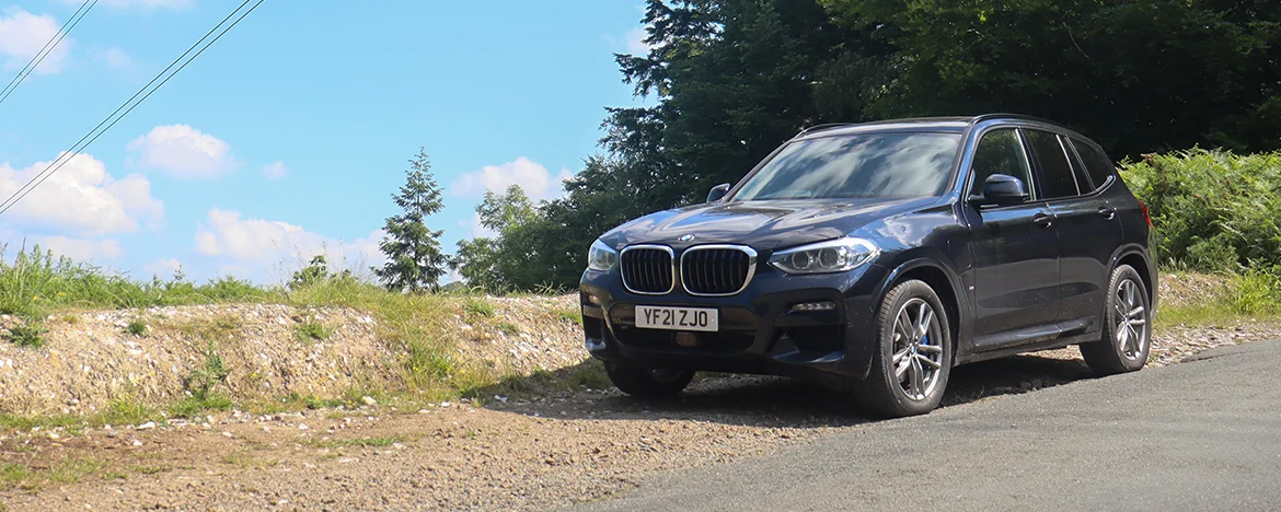 BMW X3 parked under electric pylon