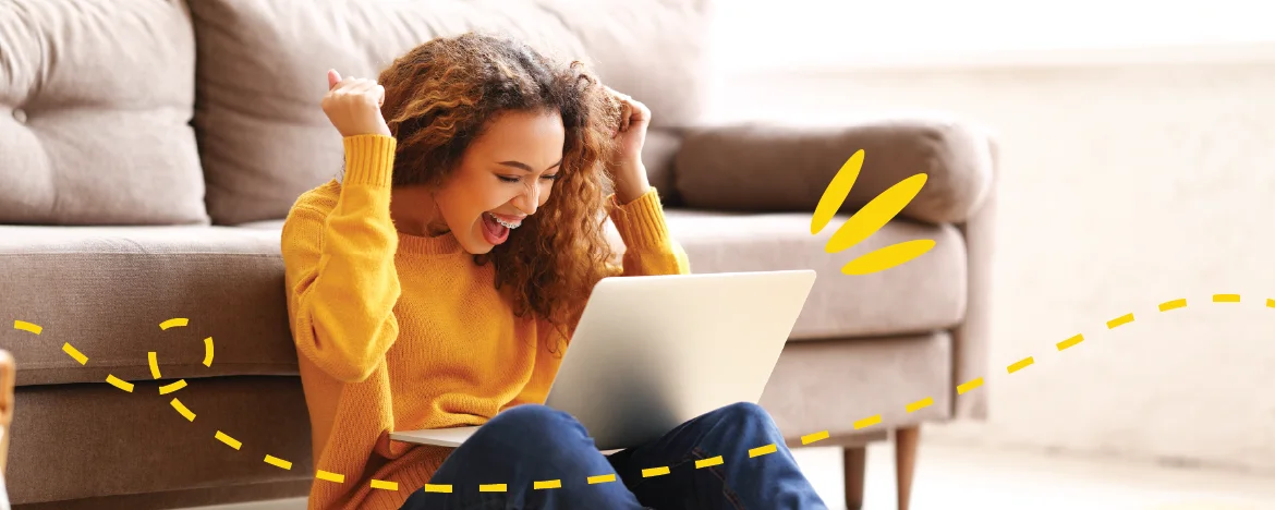 A woman cheers at her laptop