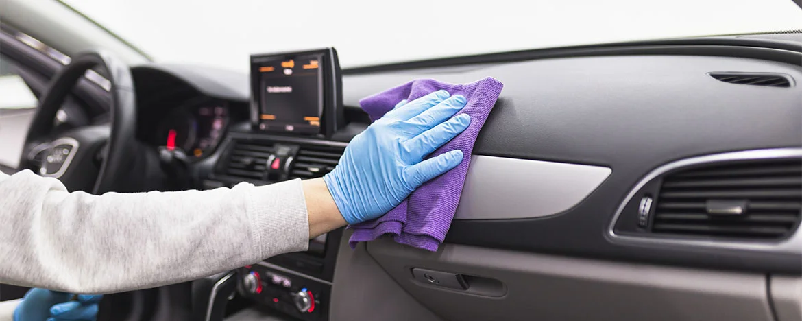 Person cleaning car dashboard