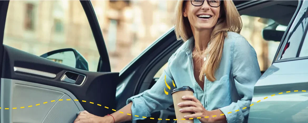 woman getting out car with coffee