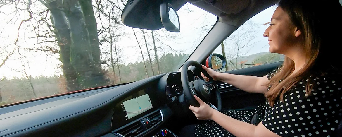 Woman smiling whilst driving the Alfa Romeo Giulia