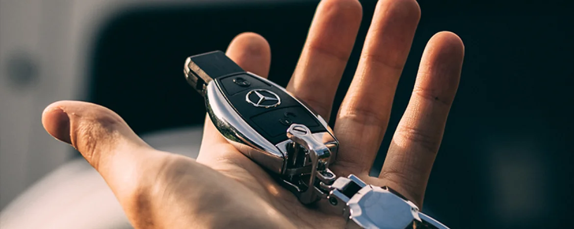 man-holding-car-key-in-front-of-car-detail