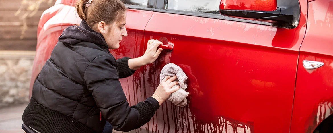 Lady washing a red car