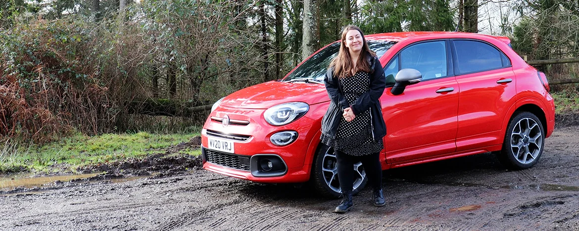 Woman standing next to Fiat 500x