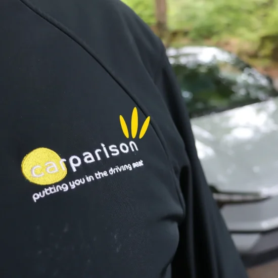 Carparison branded jacket in front of a Volvo