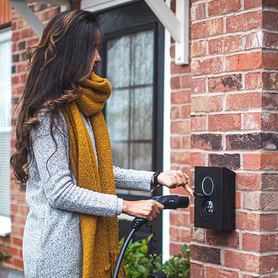 Woman using home wall box EV charger