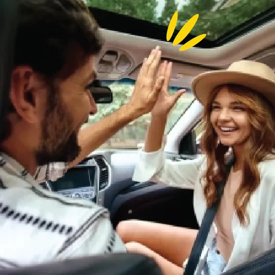 Man and woman high fiving in car
