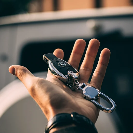 man-holding-car-key-in-front-of-car