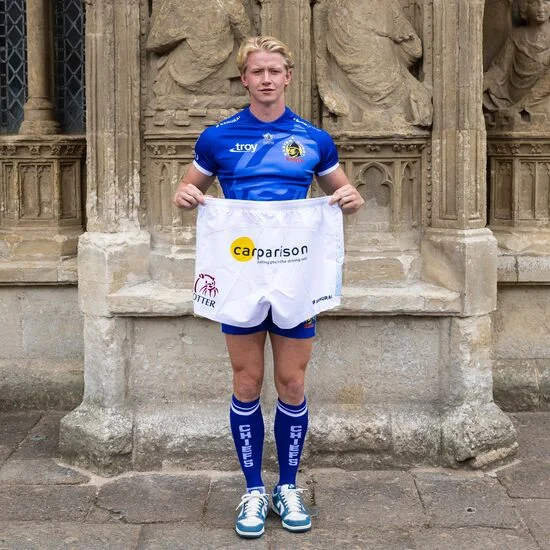 Josh Hodge holding Carparison-branded Exeter Chiefs shorts