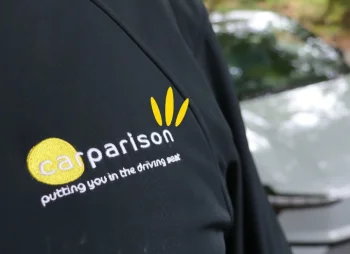 Carparison branded jacket in front of a Volvo