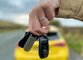 Mercedes-Benz keys in front of yellow car