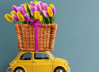 Yellow retro toy car with tulips on top