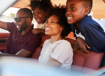 family-of-four-driving-on-summers-day