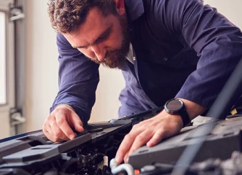 person looking under the bonnet of their car