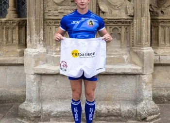 Josh Hodge holding Carparison-branded Exeter Chiefs shorts