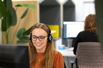 Female Carparison team member at her desk wearing a headset