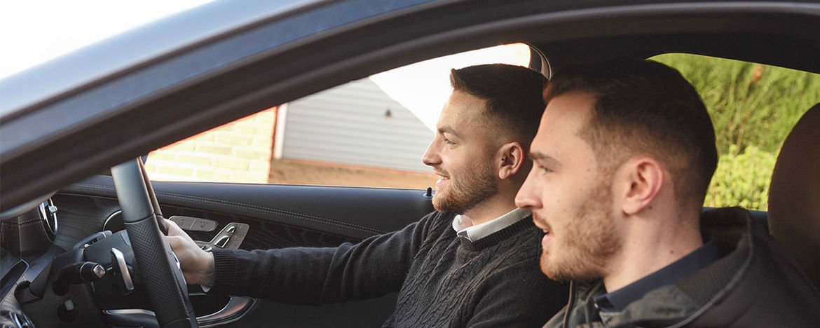 two young men in front seat of car