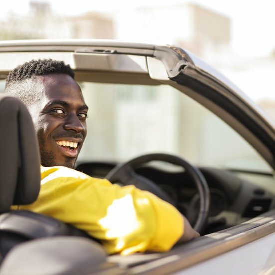 Happy person driving a convertible car