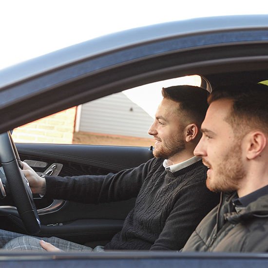 two young men in front seat of car